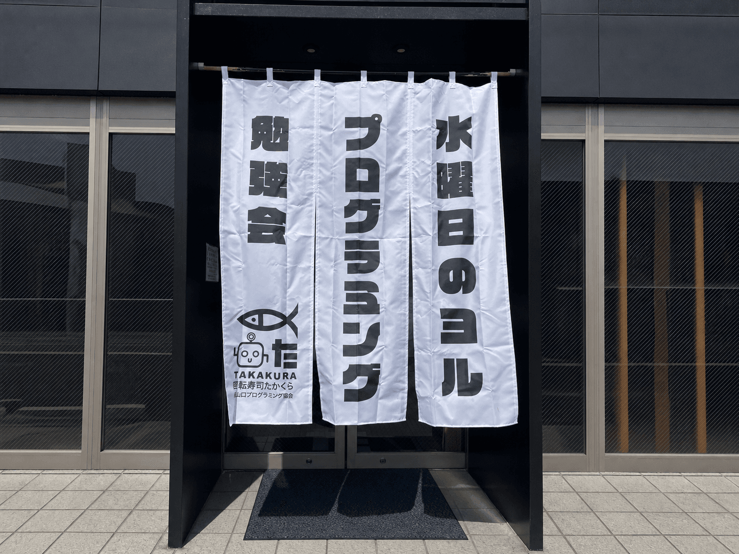 回転寿司たかくらに掲げている水曜日のヨル プログラミング勉強会の暖簾